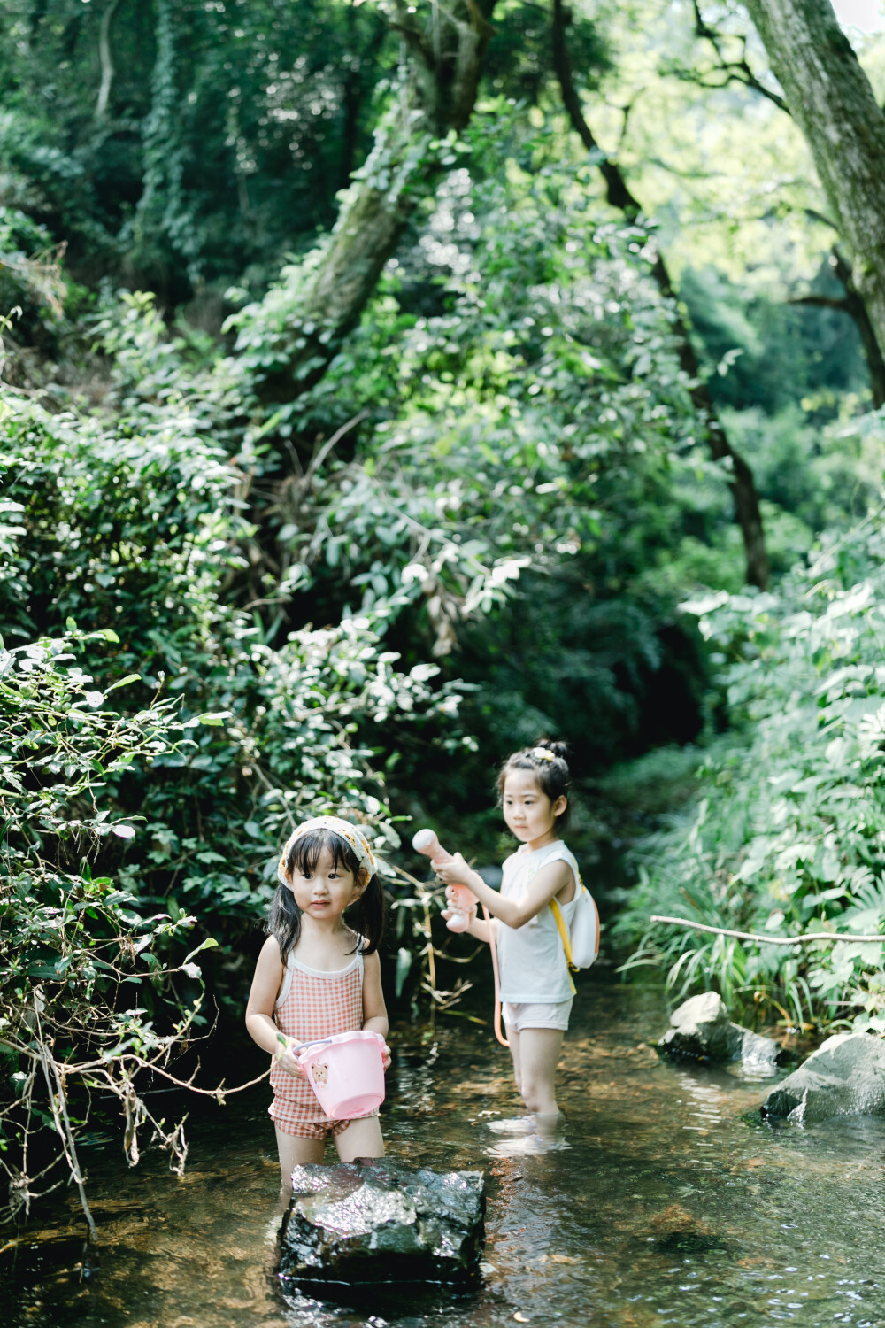 夏天總是要去九溪的
攝影：洪小漩
出鏡：菲比和格格等
每年夏天，九溪都是必去之地。
曾經(jīng)，打車是可以直達(dá)九溪煙樹的。如今，想要驅(qū)車前往，必須提前預(yù)約?；蚴墙y(tǒng)一乘坐觀光車進(jìn)入。
今日份阿科出差，兩個(gè)三口之家的出行便缺了一個(gè)壯勞力，少了一分從容。
三個(gè)大人提著裝備吃食，外加菲比三不五時(shí)鬧著要抱，我們便索性絕了步行進(jìn)入的念頭，半程觀光車，半程徒步，總算找了一小片人不算多的水域。
阿科不在，張羅菲比的我顯得十分狼狽。不過(guò)，小朋友玩得盡興，別的也就無(wú)所謂了。
一只小桶、一把水槍、一個(gè)游泳圈、一個(gè)西瓜，夏天那味便有了七八分。剩下的便是聒噪的蟬鳴和潺潺的流水。這不，今日都齊了。