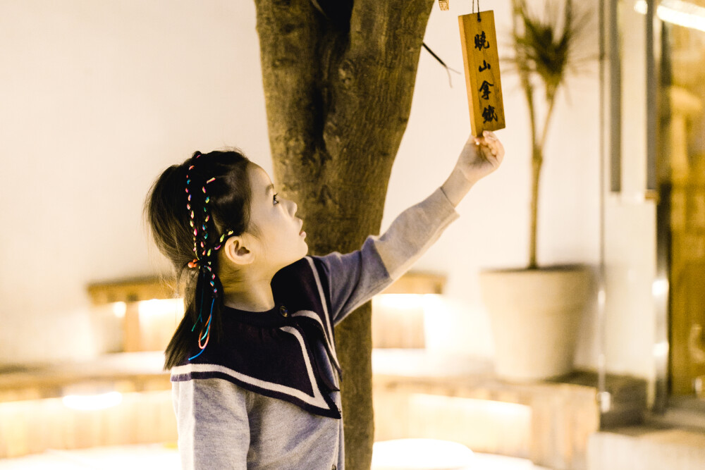 多年如一日
摄影：洪小漩
出镜：婷婷一家
说好的，一年一记录。
去年却因为时间总搭不上，遗憾失了约。
今年，十一期间在杭州工作，便腾出空来，约了同样没有回老家的婷婷一家小聚。
我蹲在楼下一边打电话，一边等婷婷们到来。他们带着大包小包朝我走来时，作为主人家的我毫不害臊地说：来就来嘛，咋还带那么多东西。
其实，我知道，因为我上完夜班来不及买菜，她们除了伴手礼，带来的更多的便是午饭的食材。
这哪里是请人家来家中做客，分明就是请人家上门做饭给我吃，还是自带食材的那种。
回到家中，婷婷和我在厨房张罗开，熙熙则和爸爸在沙发上看书聊天。
许久没见熙熙，大了不止一圈。说话也越发有大人模样。