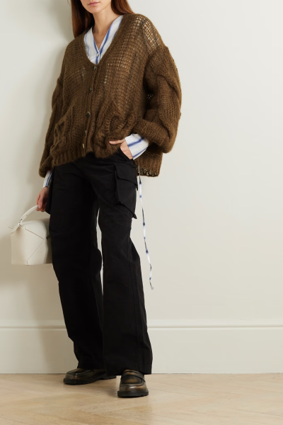 Loewe 的 “Anagram” Logo 诞生于五十年前，由西班牙艺术家 Vicente Vela 创作，如今交织在这款开衫的口袋和背面，仍然时髦动人。单品以马海毛混纺纱线织就，绞花针织宽袖和深 V 领凸显出宽大廓形。不妨将它套穿在…