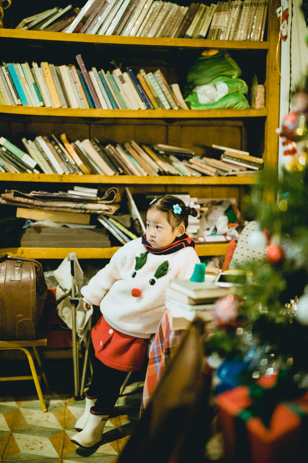 门洞
摄影：洪小漩
店铺：门洞
若非接菲比下课，我是很难发现有这样一家藏于居民楼的咖啡馆。
那天，杭州降温，原定于大兜路去看圣诞树的我们，临时决定踏进这家小店喝杯热饮。
一杯牛奶，一杯可可，外加一杯白水，在这家小店待了好一会儿。
店主是个泡面头，身形看着似乎瘦削的男生。见菲比对圣诞装置感兴趣，他过来告诉她捏捏圣诞树上的小星星会有惊喜。果然，按了后圣诞树亮起灯，唱起歌。
我环顾四周，装修上颇具巧思，满屋似乎都是老物件。他说，杭州的一切好像都在快速更新迭代，可是，明明那些东西都还能用。
于是，他从四处搜罗而来，填满这个不算大的空间。
聊天得知，这里还提供免费观影。我笑言，最近天冷