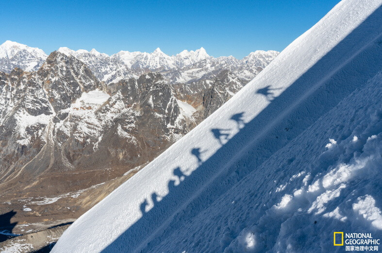 《攀登者》
在尼泊尔昆布罗布崎峰，一队登山者正在攀爬斜坡，雪地上投下了他们的影子。摄影：Brittany Mumma