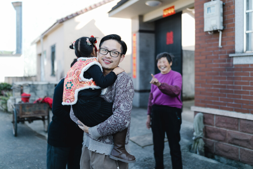 回家过年
摄影：洪小漩
出镜：家人
过年前后，因为一本电影，让“热辣滚烫”这几个字无处不在。
包括新闻标题，翻来覆去，都是它。例如，春节文旅消费“热辣滚烫”，成为拉动居民消费主力军。
的确，这个春节，身边朋友分散在五湖四海，哈尔滨、福建、云南……大家似乎都在异地找到了久违的快乐。
相比下，我的年似乎过得寡淡了些。按部就班，奔波在上虞和浦江之间。
爷爷奶奶已是耄耋之年，唯有在春节期间等来了如同候鸟一样迁徙的子女和孙辈。于我们而言，只有过年的短暂相伴，才能少些抱歉。
年二九，从杭州出发，直接忽略市区的家，奔着村里爷爷奶奶的住处而去。等我和阿科抵达，长房一家子孙就到齐了。
回到家我