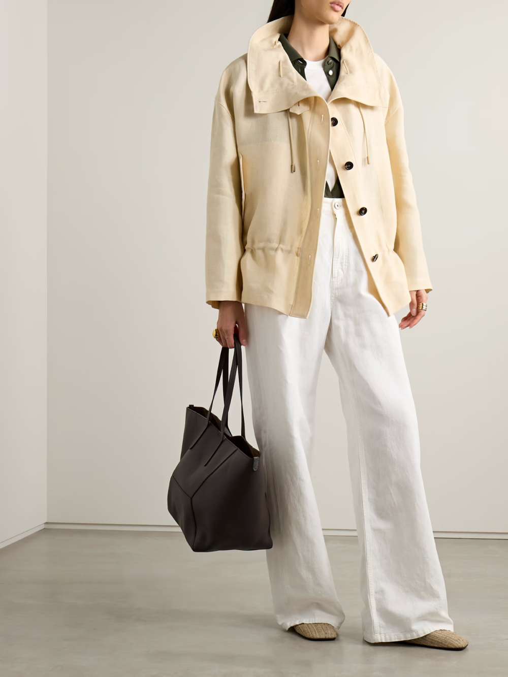 Loro Piana 这款外套裁自透气轻薄的亚麻，尤其适合换季天气。它版型宽松，漏斗领配有可调节松紧的棒形扣，天然水牛角纽扣再添经典气息。米色衣身格外百搭。