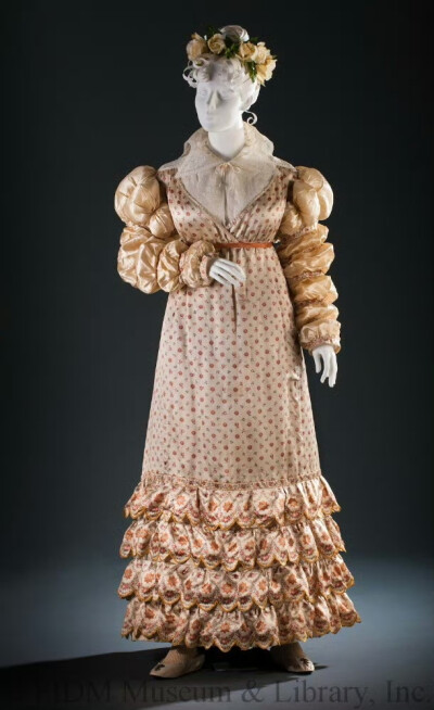 摄政王乔治的独生女夏洛特·奥古斯塔公主在约1817年穿的一件裙子，是我见过的最鼓鼓囊囊的衣服之一。细印花绸裙的下摆叠了四层花哨的波浪边，缎子藕节袖显得非常肥壮，充分展现了晚期帝政裙那变得僵硬且装饰过度的倾…