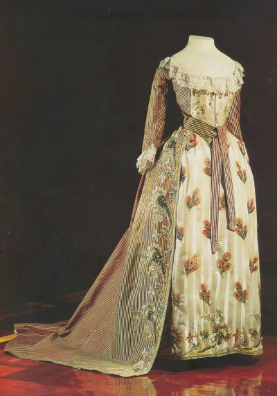 俄国太子妃玛丽亚·费奥多罗夫娜在1780年代穿的一件裙子，外层是细密的红白条纹，内层是白色与象牙色宽条纹，两层裙边都用彩线绣出繁花饰边，而内层上又分布着孔雀翎般的图案，很能体现十八世纪晚期女装推崇的既精美…