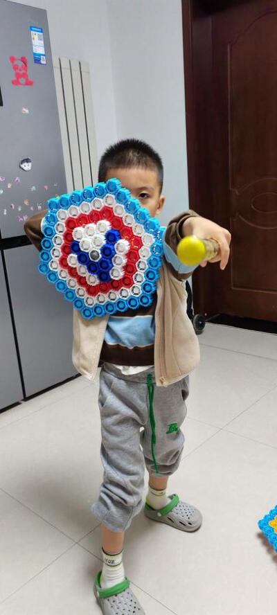 幼儿园布置的瓶盖手工作业，儿子用小瓶盖积木拼的超级英雄盾牌