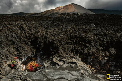 《通向熔岩的开口》
在西班牙加那利群岛的塔霍加特火山一个温度约为60℃的熔岩管开口内，洞穴专家们在采集熔岩样本进行成分化验。摄影：Arturo Rodríguez