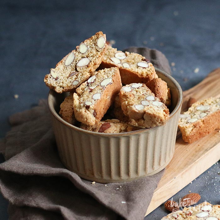 意大利甜品 Cantuccini 意式杏仁脆饼 诞生于中世纪托斯卡尼地区的传统点心，由各类干果或坚果制成的杏仁风味硬饼干，从里到外酥香爽脆。被咬断时还会发出细小的声响，因此命名时便参考了在意大利语中有着“微弱的歌声”这个意思的单=词“Cantocci/Cantucci”。由于太硬，意大利人常常把它浸在餐后葡萄酒(例如意大利甜白葡萄酒“Vin Santo”)或咖啡等饮料中，泡软之后再取出食用。添加了杏仁的意式长条饼干，是下午茶的极佳伴侣，蘸着咖啡或茶更是别有一番风味。加入杏仁也可以看做 Cantuccini Toscani O Biscotti di Prato