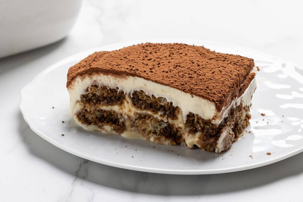 意大利甜品 Tiramisù 提拉米苏 诞生于意大利北部的威尼托大区，字面意思是 “让我振作起来”，指的是糖、酒和咖啡的提神作用。以马斯卡彭芝士、蛋黄和糖作为主要材料，以经过意式浓缩咖啡或朗姆酒浸泡的手指饼干取代传统的海绵蛋糕，最后在表面撒上一层可可粉。传统配方是完全不需要酒精的，加入产自西西里岛由白兰地强化的马萨拉白葡萄酒（Marsala）可使提拉米苏散发出优雅醇美的芬芳。 此外也有添加其它雪莉酒和果酒的配方