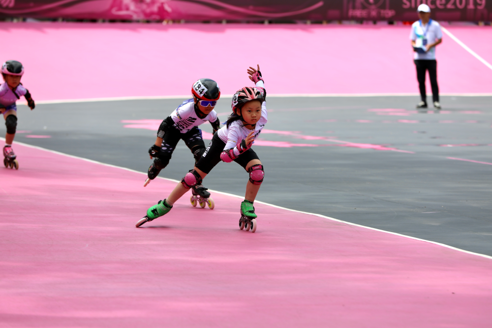 2025年全国轮滑（速度轮滑）公开赛（北京朝阳站）刚刚落下帷幕，来自全国各地的速度轮滑爱好者秉承着对速滑的热爱纷纷而至。锦州伟东轮滑俱乐部的小队员们坐上了开往北京朝阳站的高铁，一路上欢歌笑语，满怀着兴奋而又激动的心情去参加这场公开赛。在第一天适应场地之余，小队员们去了天安门，看了圆明园，参观了北京大学和清华大学两所高校学府，满足了他们对北京首都这座城市所有的向往和期待。
6月14日这天北京突降大雨，整整持续一天，因此比赛只能推迟并且压缩到6月15日一天进行，所有项目采取预赛一枪决的办法录取前八名颁发奖牌和证书。由于大雨刚停，场地湿滑，小龙教练精心地对每名队员做了赛前指导，并提示他们一定要躲避水坑注意安全。每次上场比赛之前，小龙教练都亲自为他们擦拭比赛轮子，生怕因为一丝的客观原因而影响比赛成绩。
第一个上场参赛的队员是季梦冉，冉冉报着一份永不服输的信念，奋力滑到了小组第一名，获得了300米第五名。在接下来的200米比赛中，冉冉更是表现出色，最终获得了第二名，落后第一名仅仅0.09秒，冉冉第一次参加全国比赛就能够取得这样优秀的成绩，不仅值得我们为她高兴喝彩，更加鼓舞了整个俱乐部的气势。
孙