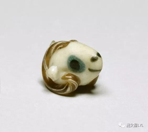 公元前五至四世纪的玻璃吊坠，呈公羊头部形状，象征着保护和生育。