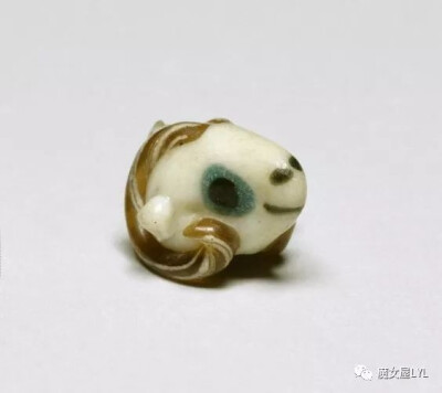 公元前五至四世纪的玻璃吊坠，呈公羊头部形状，象征着保护和生育。