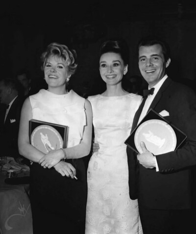 雷切尔·罗伯茨、奥黛丽·赫本和德克·博加德于1964年4月3日在伦敦希尔顿酒店举行的英国电影学院奖（BAFTA）颁奖典礼上。