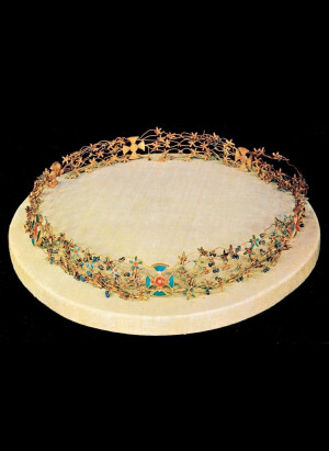 这顶精美的王冠曾属于埃及中王国时期（第十二王朝，公元前1991-1803年）的肯梅特公主，她很可能是法老阿蒙涅姆赫特二世的女儿。这顶王冠在达舒尔阿蒙涅姆赫特二世金字塔附近，与她姐姐伊塔的墓葬一起被发现，未被盗掘。王冠展现了古埃及金匠非凡的工艺和技艺。王冠由相互交织的金丝组成，形成了近200朵花，每朵花都镶嵌着一颗红玉髓“眼睛”，并有五片绿松石镶嵌的花瓣，呈现出精致而璀璨的光芒。