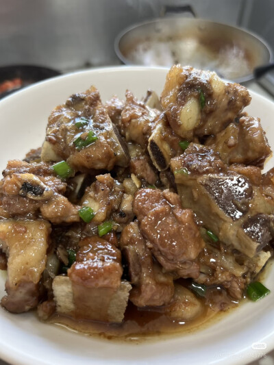 水烧开以后，排骨放料酒和生姜焯水捞出（这一步就是用开水焯水），接着烧一壶热水，放20粒单晶冰糖加油炒糖色，糖融化了马上把排骨倒进去炒，加入没过排骨的热水，一定要热水，中火炖，再用那种不锈钢的汤勺，加5勺…