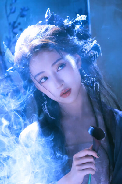 胡连馨｜烟霭朦胧处，她似从水墨里走出的仙。
银饰是星子落在发上，素衣糅着云的缥缈。
唇上那朵绯色，是风路过桃林时，偷偷藏下的春色。