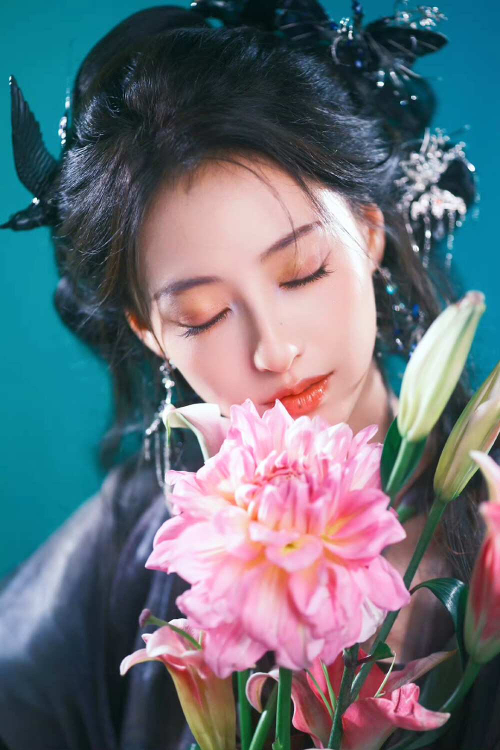 胡连馨｜烟霭朦胧处，她似从水墨里走出的仙。
银饰是星子落在发上，素衣糅着云的缥缈。
唇上那朵绯色，是风路过桃林时，偷偷藏下的春色。