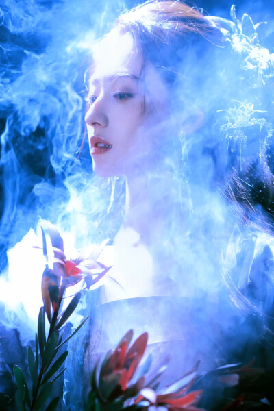 胡连馨｜烟霭朦胧处，她似从水墨里走出的仙。
银饰是星子落在发上，素衣糅着云的缥缈。
唇上那朵绯色，是风路过桃林时，偷偷藏下的春色。