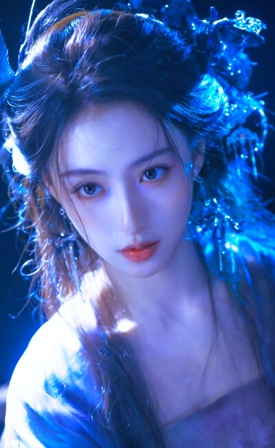 胡连馨｜烟霭朦胧处，她似从水墨里走出的仙。
银饰是星子落在发上，素衣糅着云的缥缈。
唇上那朵绯色，是风路过桃林时，偷偷藏下的春色。