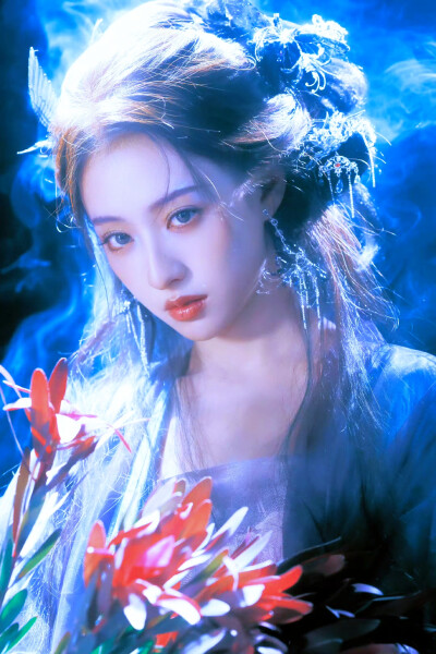 胡连馨｜烟霭朦胧处，她似从水墨里走出的仙。
银饰是星子落在发上，素衣糅着云的缥缈。
唇上那朵绯色，是风路过桃林时，偷偷藏下的春色。