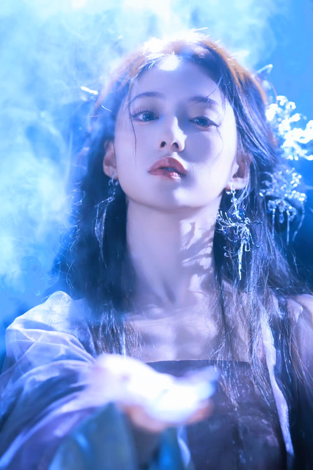 胡连馨｜烟霭朦胧处，她似从水墨里走出的仙。
银饰是星子落在发上，素衣糅着云的缥缈。
唇上那朵绯色，是风路过桃林时，偷偷藏下的春色。