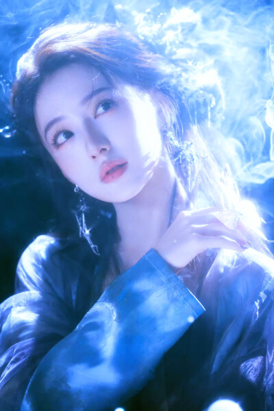 胡连馨｜烟霭朦胧处，她似从水墨里走出的仙。
银饰是星子落在发上，素衣糅着云的缥缈。
唇上那朵绯色，是风路过桃林时，偷偷藏下的春色。