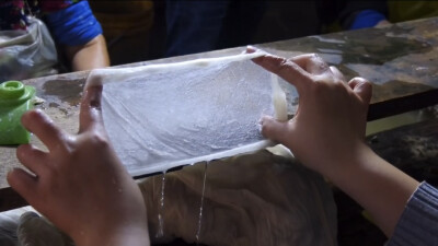 一茧一世界，一指一浮沉
每剥一个茧，像开启自然的盲盒一拉一扯一撑，形成一张张晶莹剔透的绵兜，匀而不散，这慢工细活里，有对自然的敬意，也有对品质的坚守。