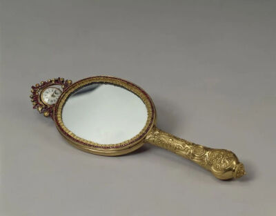 ▲ [法] 铜镀金嵌料石把镜表，18世纪通长32厘米，宽10厘米，厚1.5厘米，表径3.5厘米故宫博物院藏