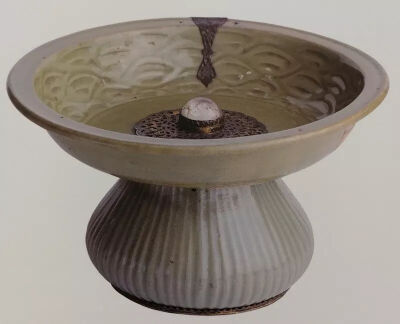 ▲ 14世纪上半叶的青瓷高足盘，由倒置的罐子和深口盘接合而成，17世纪奥斯曼工匠在二者底部各钻一孔，以曲头银钉连接土耳其伊斯坦布尔 托普卡帕宫藏