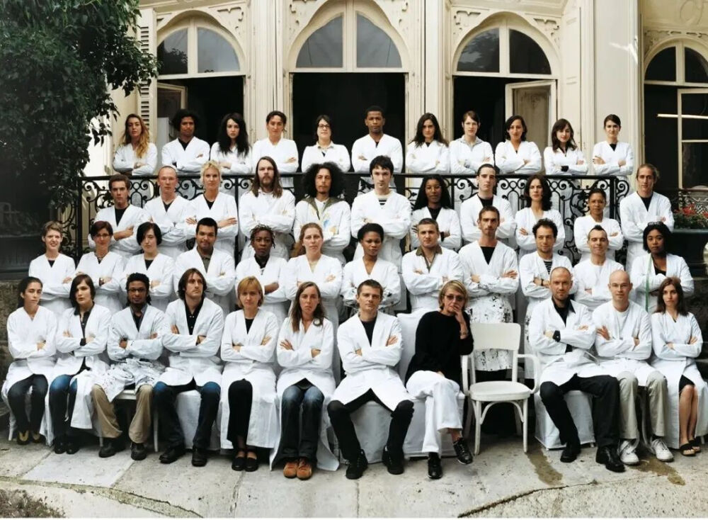 Maison Martin Margiela 团队于2001年拍摄的合照，其中空缺的椅子为缺席合影的 Martin Margiela