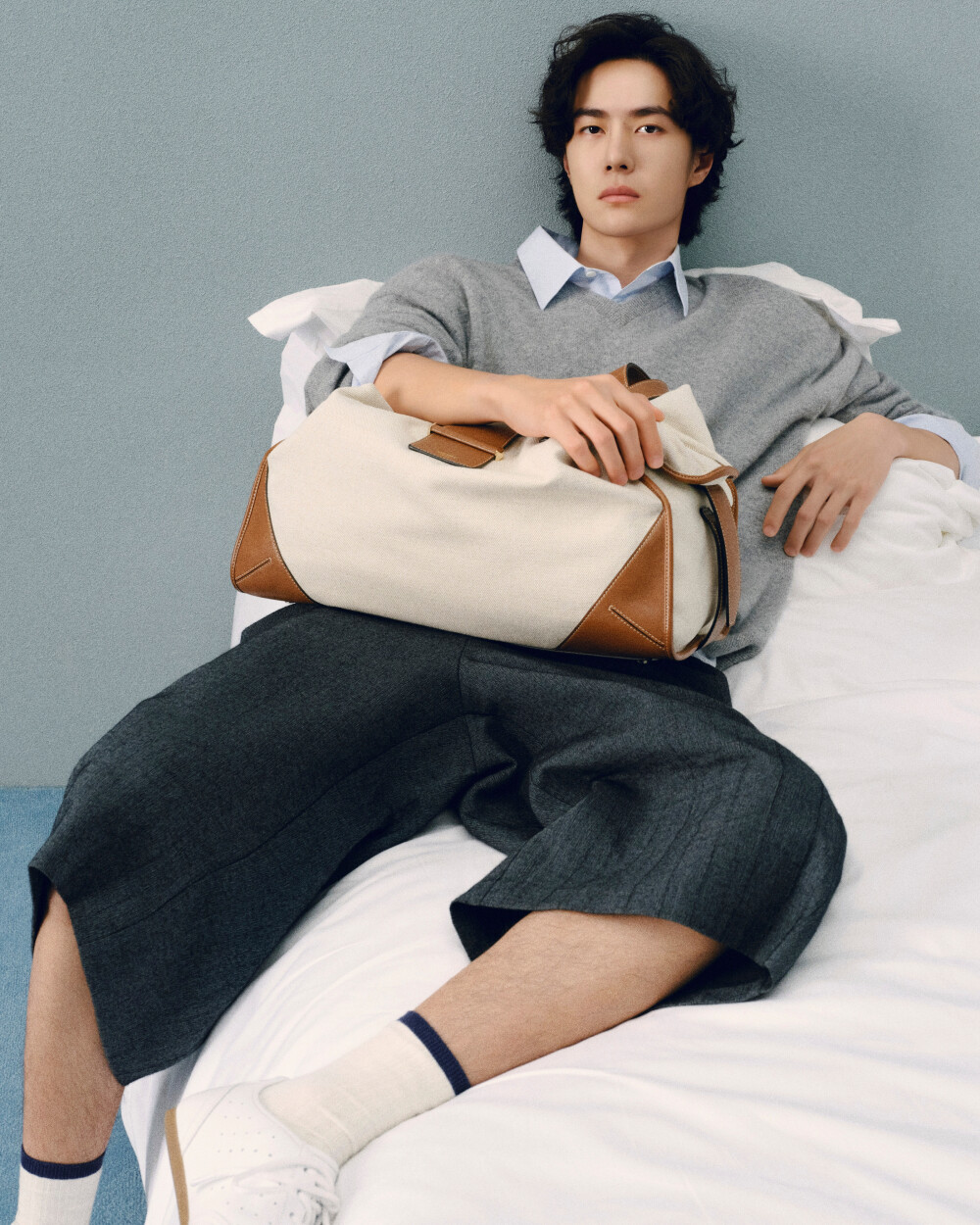 Jimmy-Choo：
全球品牌代言人@王一博·YIBO 穿着白色Sunny薄底休闲鞋，搭配棕色皮革饰边帆布款Bar Holdall旅行袋，释出慵懒自在的惬意氛围。