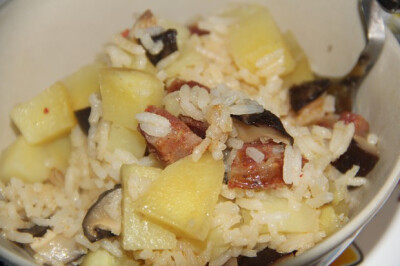 腊肠土豆香菇焖饭 - 老干妈是对厨房望而生畏的宅男宅女的女神，焖饭则是电饭煲青年的心头好。炒锅和炖锅失踪以后，想要做东西吃好像只能依赖电饭煲了。东拼西凑，竟然有了这样一锅焖饭。米饭干韧，土豆粉糯，香菇带…