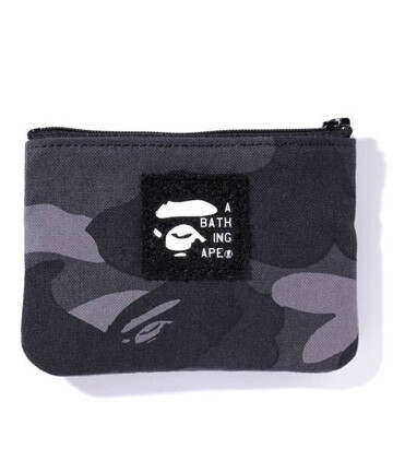 A BATHING APE - 此款1ST CAMO TISSUE POUCH同样为全迷彩设计，正面加载复古猿人头LOGO标贴，形状与容量的设计可存放大部分的卡片与零钱，是一款不可缺少的小物包。