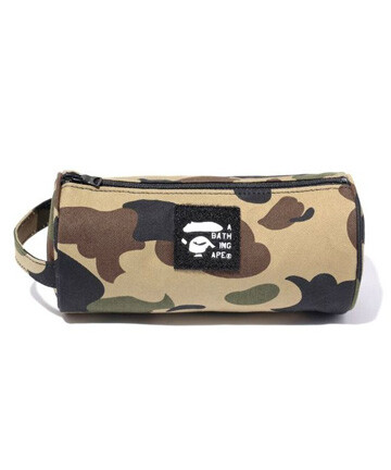 A BATHING APE - 此款1ST CAMO TUBE POUCH同样为全迷彩设计，正面加载复古猿人头LOGO标贴，较大容量的设计可存放大部分的日常用品，实用度颇高。