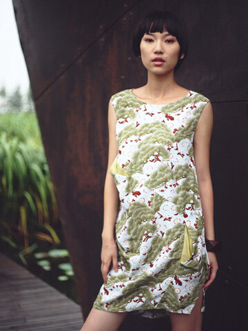 青松蓝樱有诗意的图案，不对称的切片裁剪的连身裙，简单的绿意中带了点点猩红，使人无比清醒。