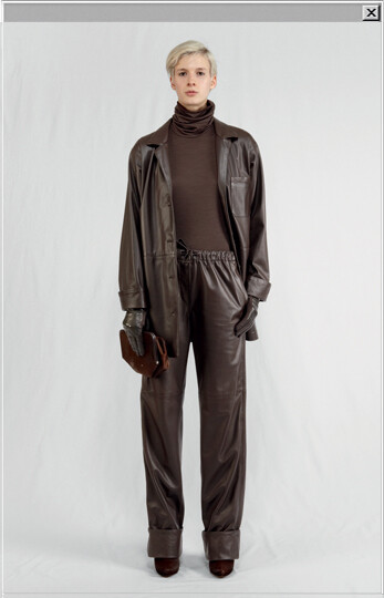 Replica leather pajamas jacket worn with Replica leather pajamas pants, a jersey roll-neck sweater, long leather and wool gloves, a clutch bag in poney-style leather and boots in poney-style leather.