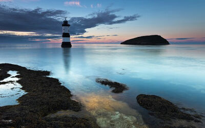 英国北威尔士的彭蒙灯塔，Penmon灯塔位于英国威尔士的安格尔西岛，旁边的角嘴海雀岛是这种海鸟的栖息地之一。Penmon Lighthouse and Puffin Island at Penmon Point on the Isle of Anglesey, Wales, UK