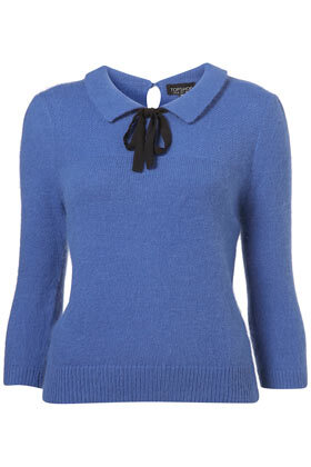 Knitted cornflower blue short fluffy top with 3/4 sleeves, collar and contrast grosgrain ribbon tie detail at the neck. 58% Nylon,37% Angora,5% Wool.