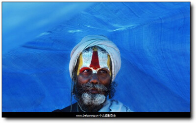 Wednesday, January 19, 2011一年一度的Magh Mela节期间，一名印度教信徒站在蓝色的帐篷下，阿拉哈巴德，印度。摄影师：Rajesh Kumar Singh