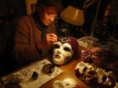 威尼斯的面具画家 。在威尼斯的一家小店里，一个女人用手工来描绘面具。在她店里所有的面具都是这样做的。