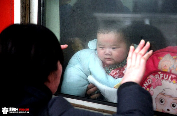 2011年1月23日，南京火车站站台，一位母亲隔着车窗与孩子道别。