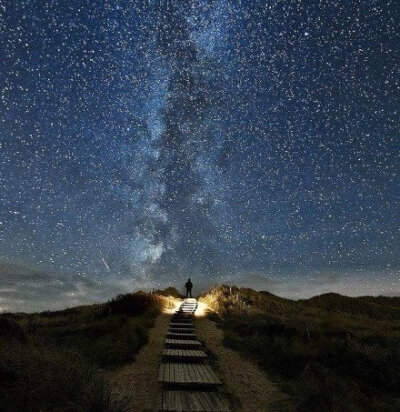 【摄影师拍到通往银河系的星路】英国《太阳报》报道，48岁的摄影师托马斯-兹米尔在德国最北部叙尔特岛海滩归来时拍到了令人惊叹的夜景照片，一行阶梯看起来直接通往银河系。他说：“银河系就在阶梯尽头，我感到很震…