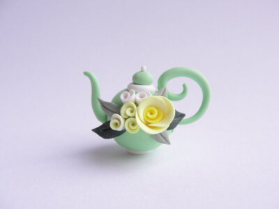 Miniature pale green teapot with pale yellow rose