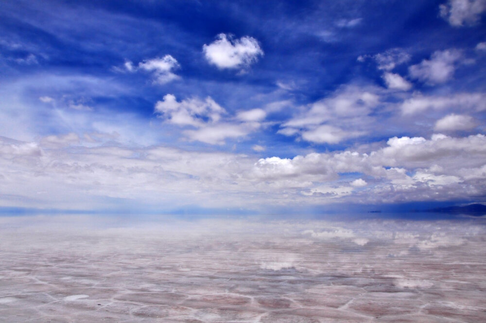 传说中的天空之镜是乌尤尼盐沼（Salar de Uyuni），它位于玻利维亚西南部的乌尤尼小镇附近，是世界最大的盐沼，东西长约250公里，南北宽约100公里，面积达10,582平方公里，盛产岩盐与石膏。由于面积大，表面光滑，反射率高，覆盖着浅水，以及最小的海拔差，阿塔卡玛成为一个理想测试和校准的遥感仪器对轨道卫星，用来研究地球。