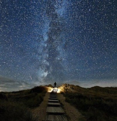 【摄影师拍到通往银河系的星路】英国《太阳报》报道，48岁的摄影师托马斯-兹米尔在德国最北部叙尔特岛海滩归来时拍到了令人惊叹的夜景照片，一行阶梯看起来直接通往银河系。他说：“银河系就在阶梯尽头，我感到很震…