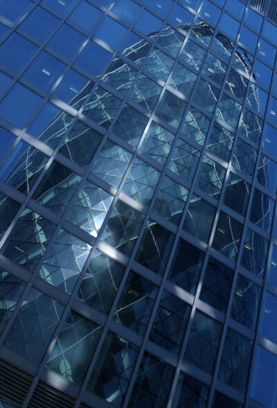 Photograph of Gherkin reflected off adjacent glass buildimg