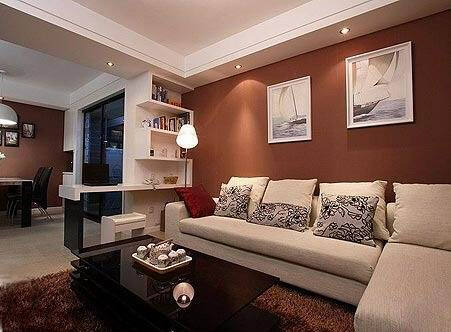 红色墙面漆作为沙发的背景墙显得格外大气，白色转角沙发平添了温馨雅致的美感。简洁的挂画和射灯的效果为简约的红色墙面增添了动人的效果。