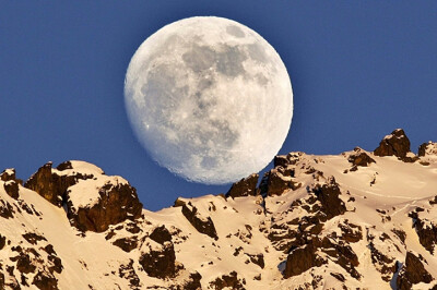 圆月当空：2012年2月5日，瑞士席尔瓦普拉纳，月亮从罗萨奇峰（Piz Rosatsch Mountain）上升起，落日的最后一缕光线映照在山脊上。 （图片来源：Arno Balzarini/Keystone/欧洲图片新闻社）