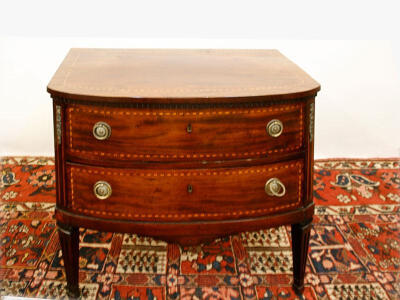 A fine George III Sheraton bow front mahogany commode with satinwood banding, two drawers on fluted square tapering supports.