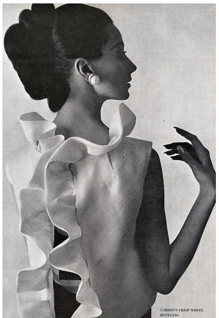 Bettina Lauer in white silk gazar ruffled jacket worn over a navy blue faille long dress by Pierre Cardin photo by William Klein Vogue US March 1963